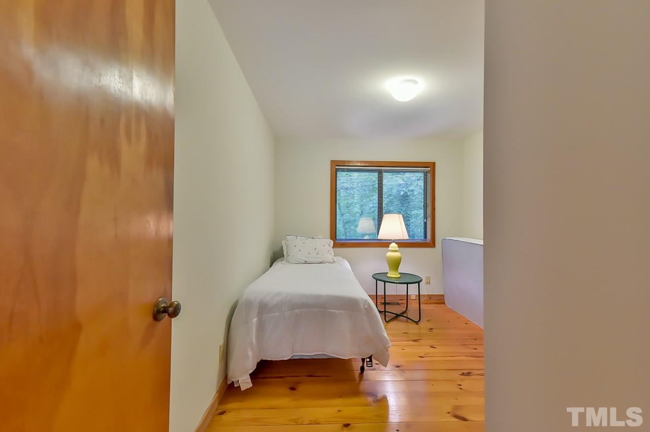 214 Clark Lake Road Durham, NC 27707 - Photo 12 of 30 a bedroom with a bed and a table in it