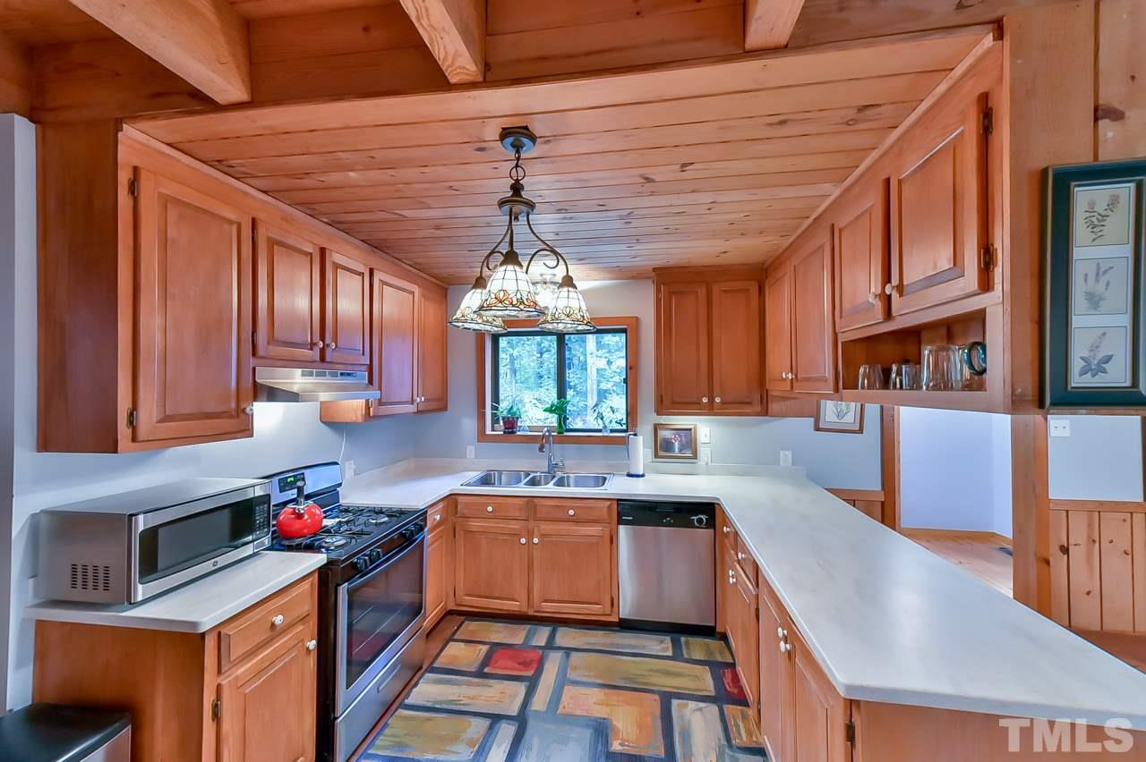 214 Clark Lake Road Durham, NC 27707 - Photo 14 of 30 a kitchen with stainless steel appliances granite countertop a sink dishwasher and cabinets with wooden floor