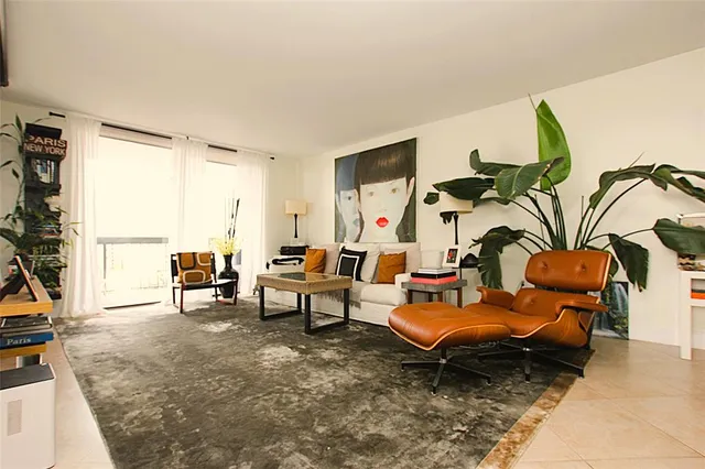 a living room with furniture and a floor to ceiling window