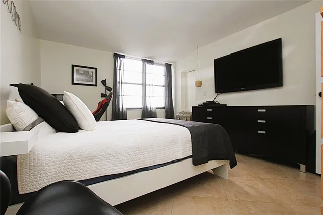 a bedroom with a bed and a flat screen tv