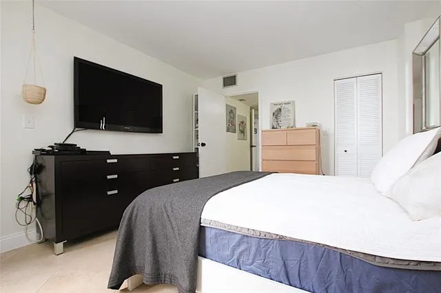 a bedroom with a bed and a flat screen tv