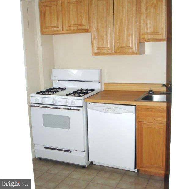 823 Kevin Road Baltimore, MD 21229 - Photo 4 of 12 a kitchen with granite countertop white cabinets and a stove top oven