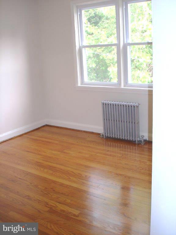 823 Kevin Road Baltimore, MD 21229 - Photo 8 of 12 an empty room with wooden floor and windows
