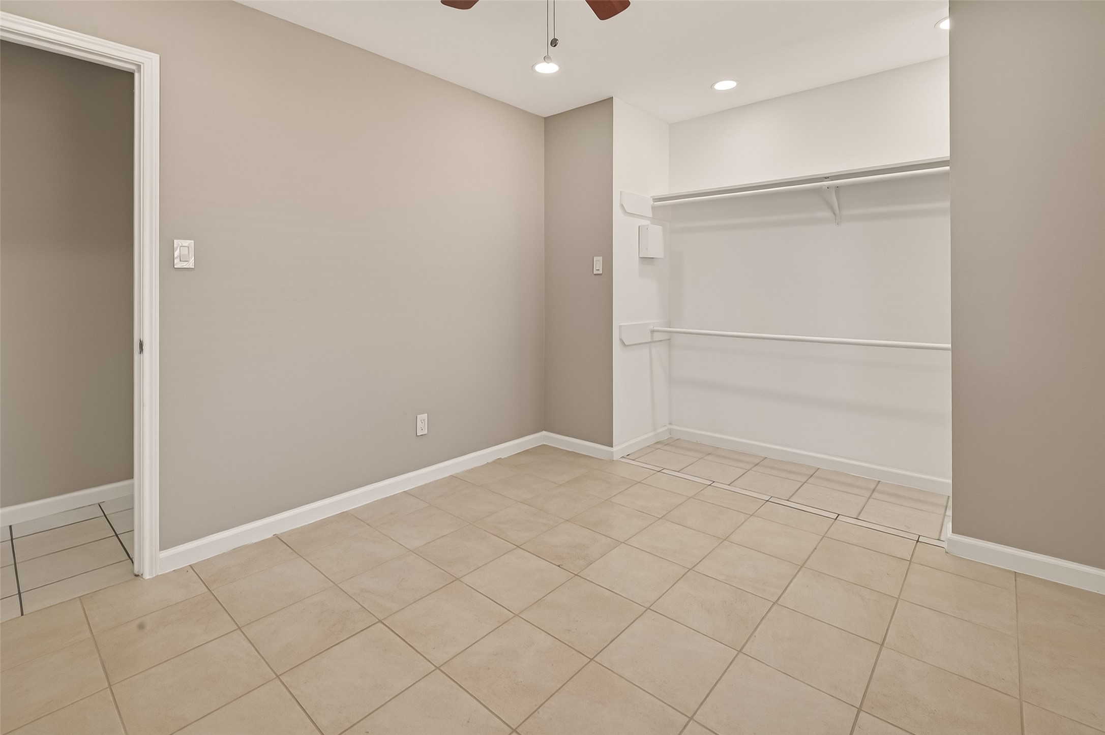 10810 Umber Court Houston, TX 77099 - Photo 17 of 43 View of the bedroom’s generous closet space, showcasing the clean lines of the open closet and the neutral color palette that extends throughout the room.