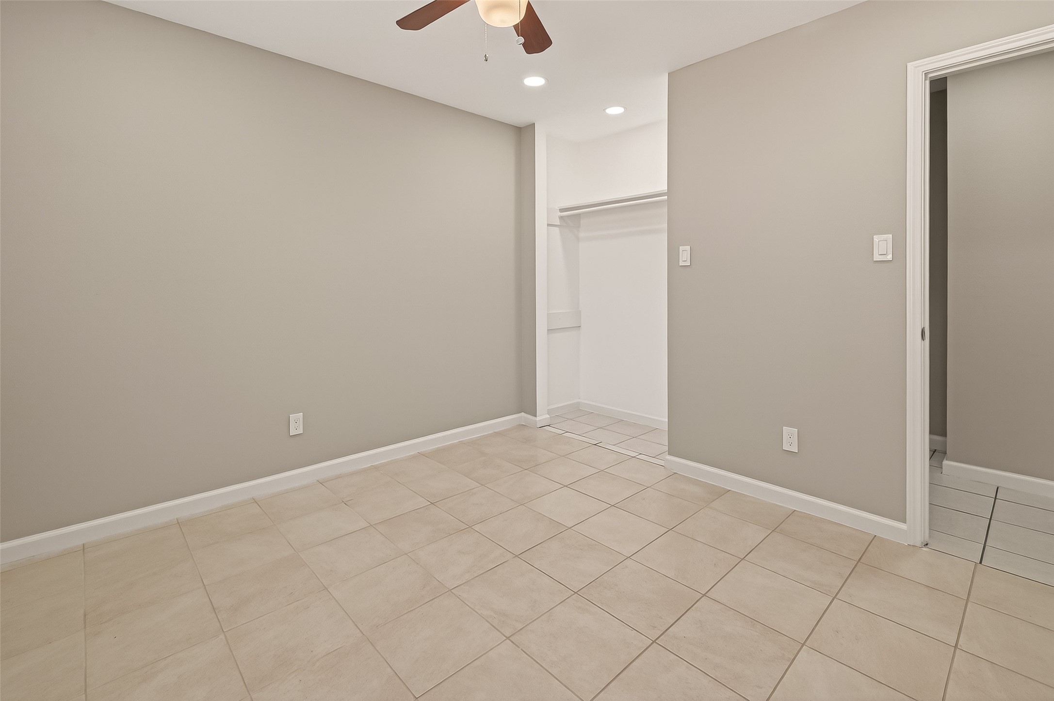 10810 Umber Court Houston, TX 77099 - Photo 20 of 43 Designed with flexibility in mind, this room offers plenty of wall space for various furniture layouts. The seamless transition of the tile flooring and the recessed lighting overhead create a polished, modern feel.