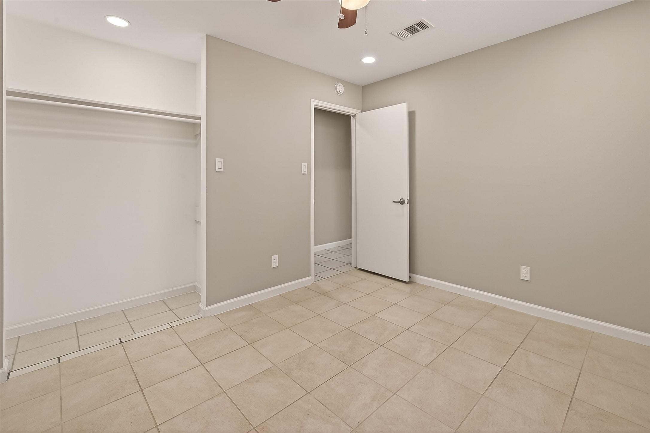 10810 Umber Court Houston, TX 77099 - Photo 21 of 43 Storage is made simple with a dedicated open closet area featuring built-in shelving and hanging rods. The wide doorway and clean, neutral palette make this room feel spacious and move-in ready.