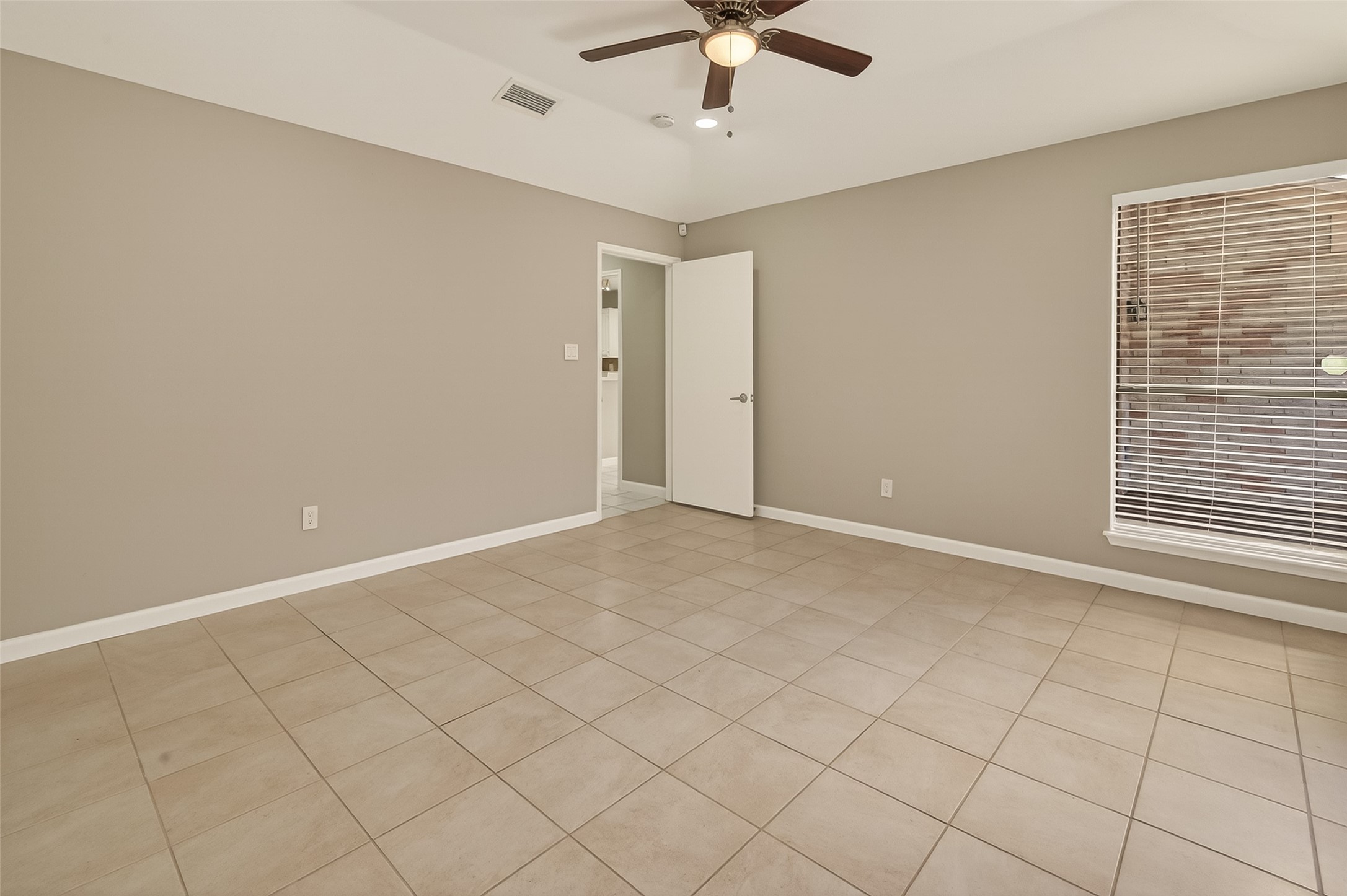 10810 Umber Court Houston, TX 77099 - Photo 24 of 43 The primary bedroom is a true retreat, offering a spacious layout with high vaulted ceilings that create an open, airy feel. Large windows overlook the deck, filling the room with natural light and providing a peaceful view to start your day.