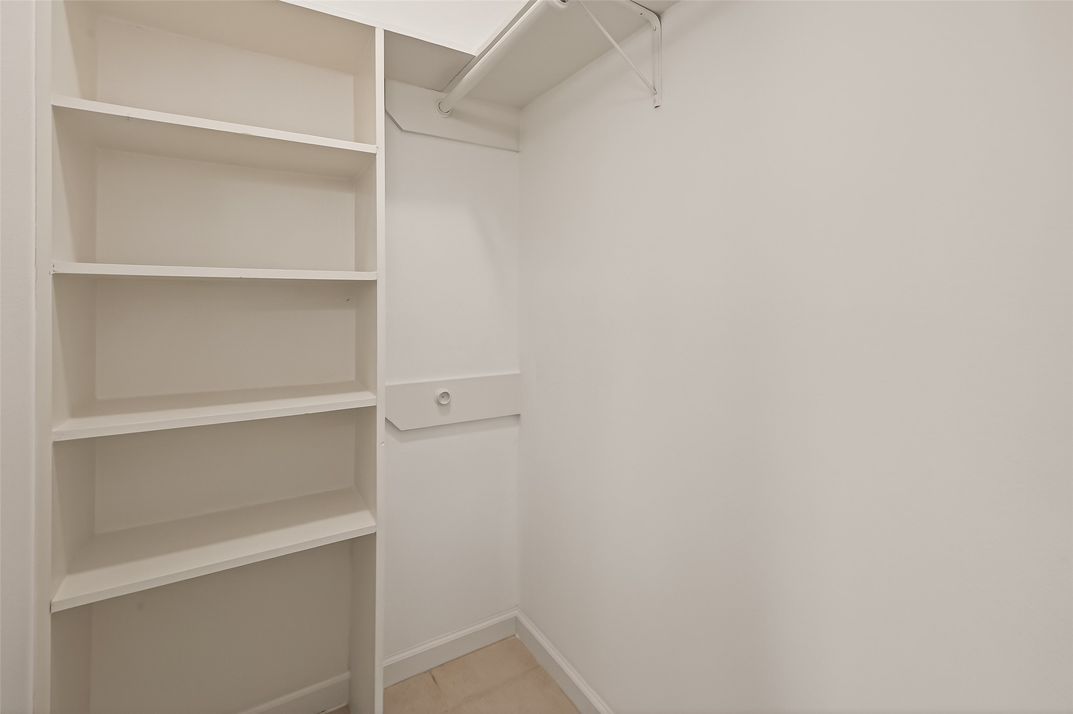 10810 Umber Court Houston, TX 77099 - Photo 33 of 43 One of two spacious walk-in closets located within the primary bathroom, offering extensive built-in shelving and hanging rods. This setup ensures organized, dedicated storage for every wardrobe