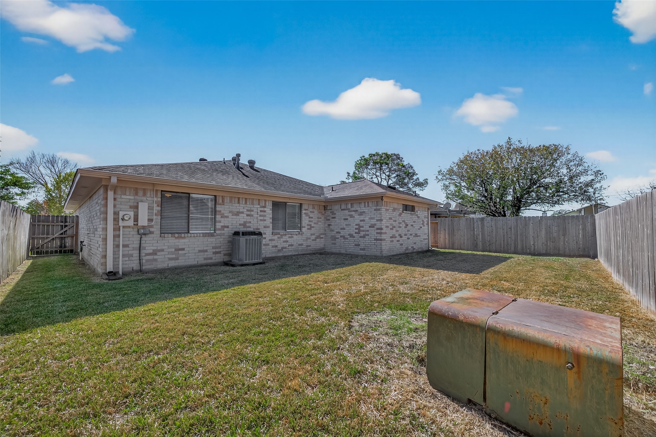 10810 Umber Court Houston, TX 77099 - Photo 40 of 43 Showcasing the home’s quality, this view highlights the impressive four-sided brick exterior that extends all the way to the back for lasting durability. The transition from the elevated deck to the manicured yard offers a clean, organized layout for all your outdoor activities