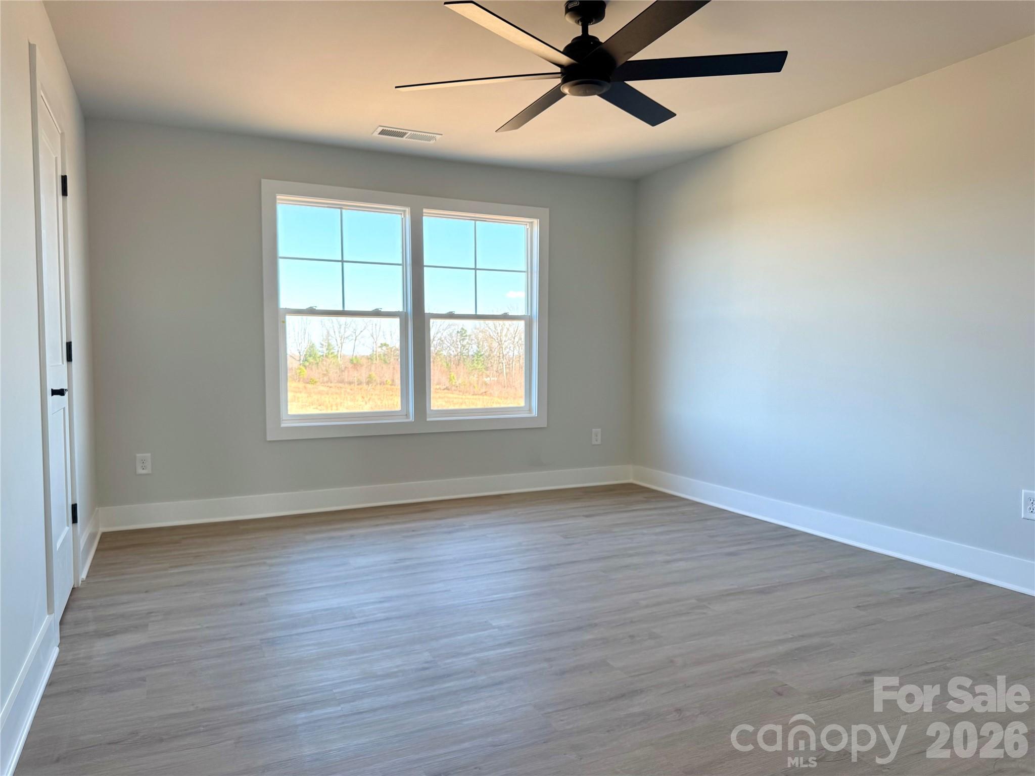 118 Doby Road Mocksville, NC 27028 - Photo 11 of 19 an empty room with wooden floor fan and windows