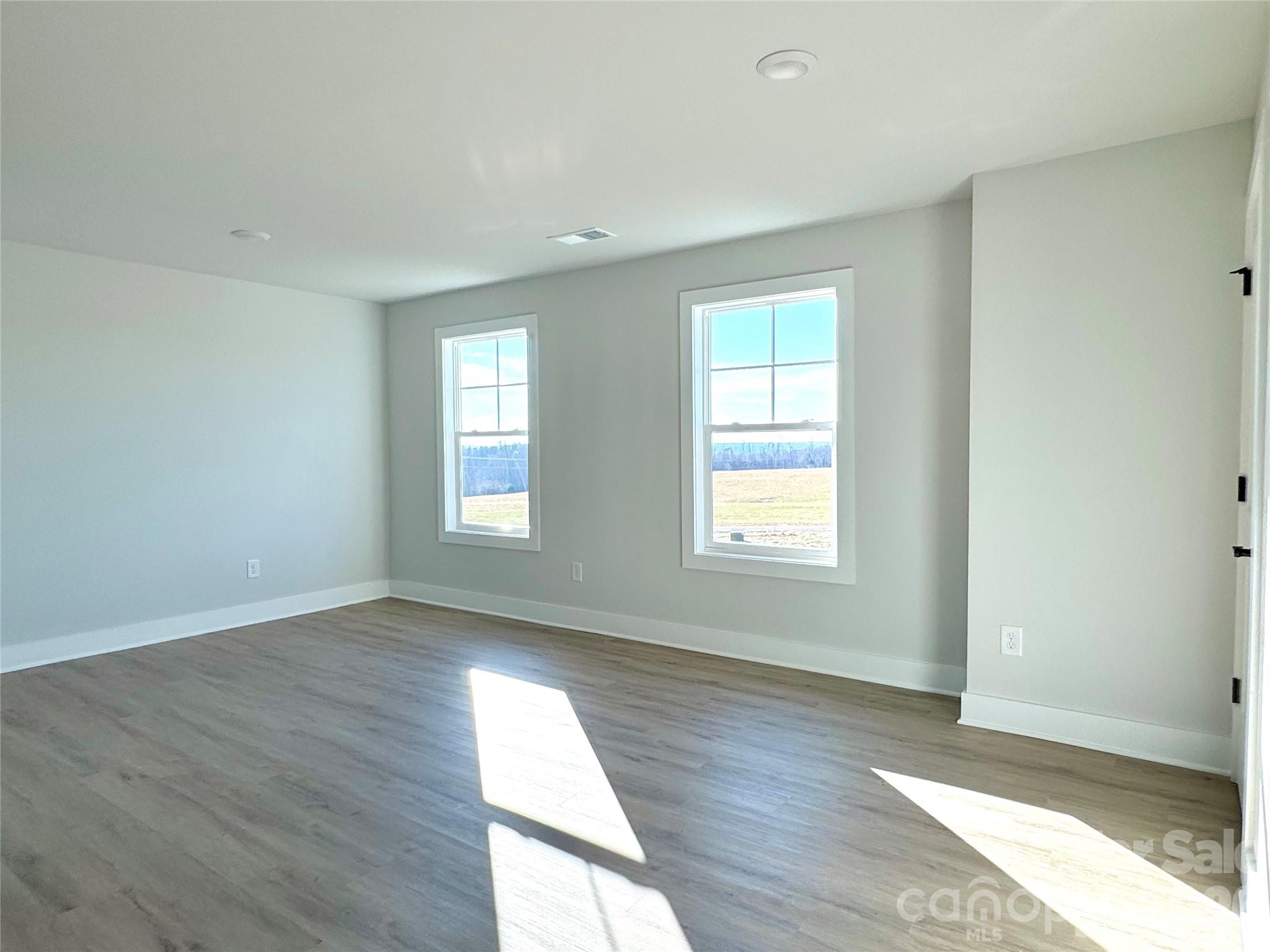 118 Doby Road Mocksville, NC 27028 - Photo 14 of 19 an empty room with wooden floor and windows