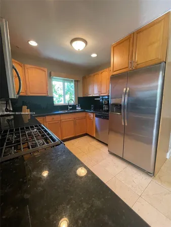 a kitchen with stainless steel appliances a sink stove and refrigerator