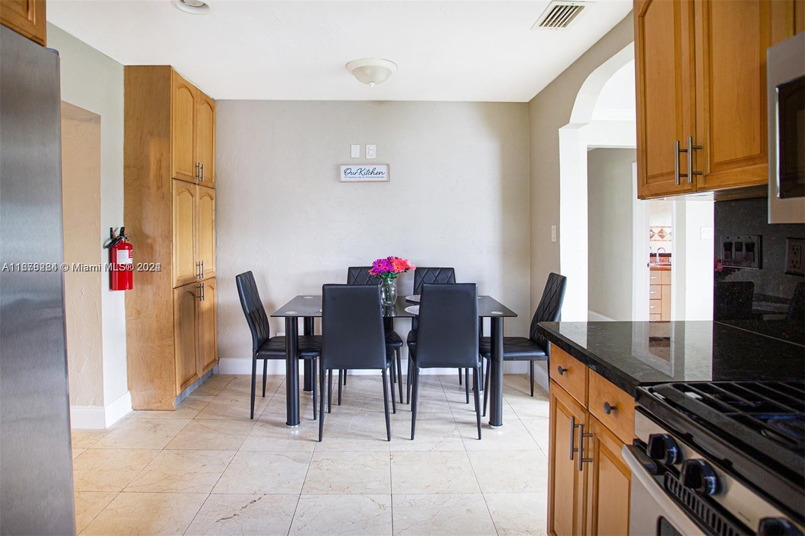 1531 Moffett Street Hollywood, FL 33020 - Photo 5 of 34 a kitchen with stainless steel appliances stove top oven table and chairs