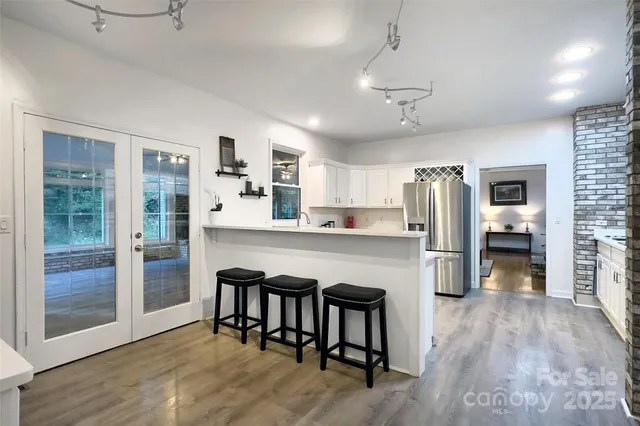 a kitchen with white cabinets and sink