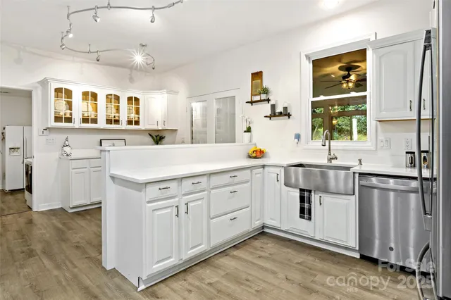 a kitchen with white cabinets and stainless steel appliances