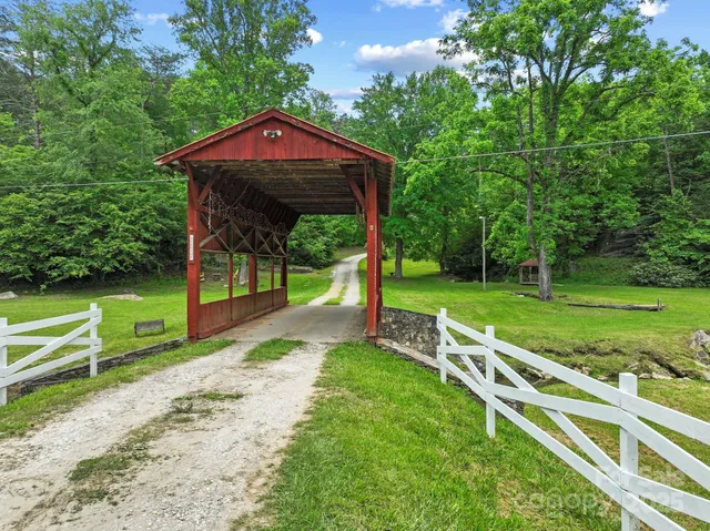 a view of a park with large trees and a barn in it