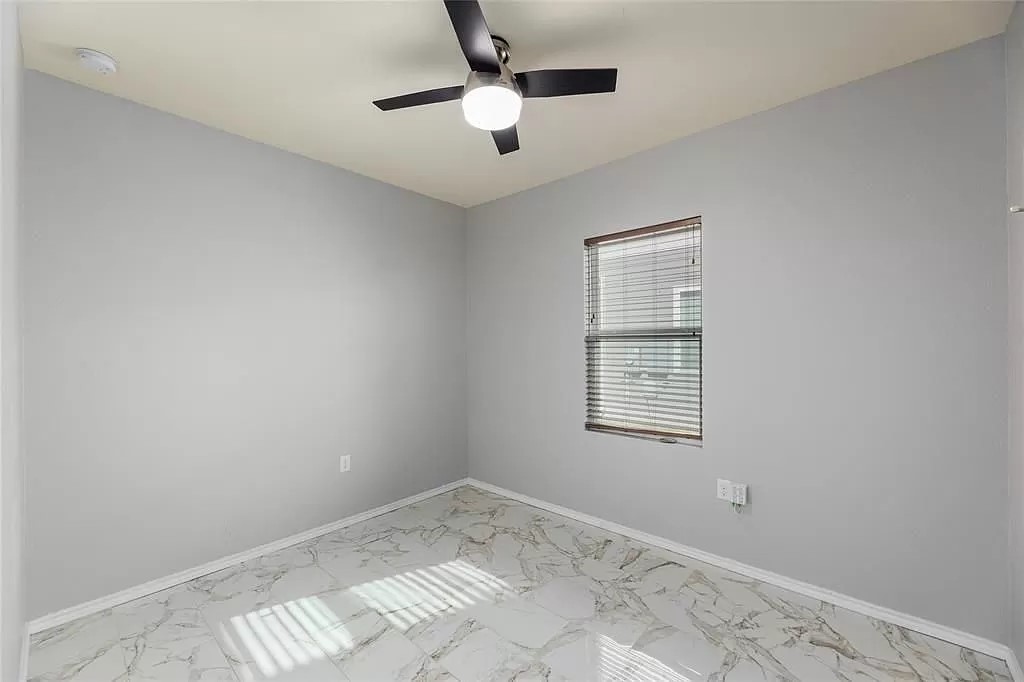 13021 Foreston Drive Austin, TX 78754 - Photo 12 of 17 Unfurnished room with marble look tiles and a ceiling fan