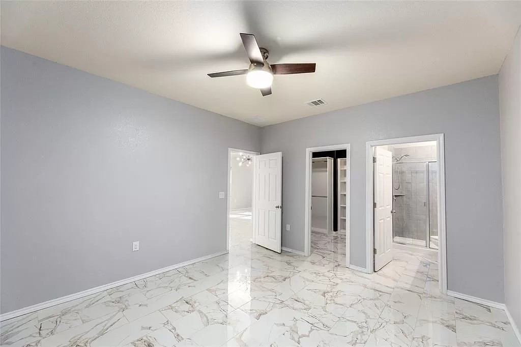 13021 Foreston Drive Austin, TX 78754 - Photo 8 of 17 Unfurnished bedroom with a spacious closet, light marble finish floors, a ceiling fan, and ensuite bath