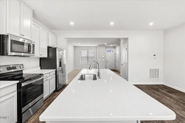 a kitchen with stainless steel appliances granite countertop a refrigerator a stove top oven a sink and dishwasher