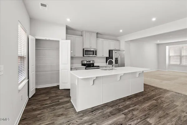a kitchen with stainless steel appliances a refrigerator and a stove top oven