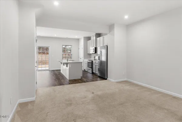 a view of a kitchen with refrigerator and wooden floor