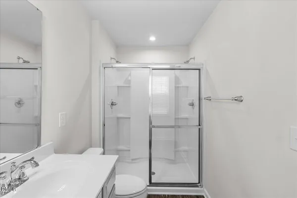 a bathroom with a shower a toilet and sink