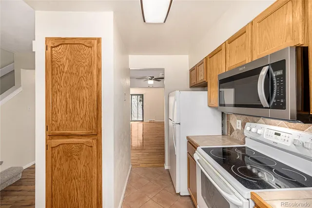 a kitchen with stainless steel appliances granite countertop a refrigerator and a stove top oven