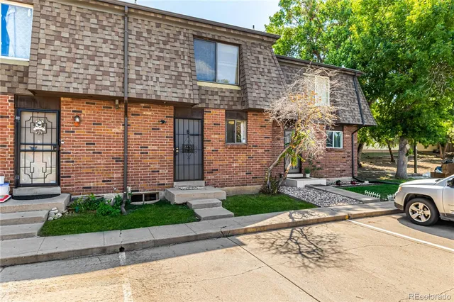 a front view of a house with a garden and parking