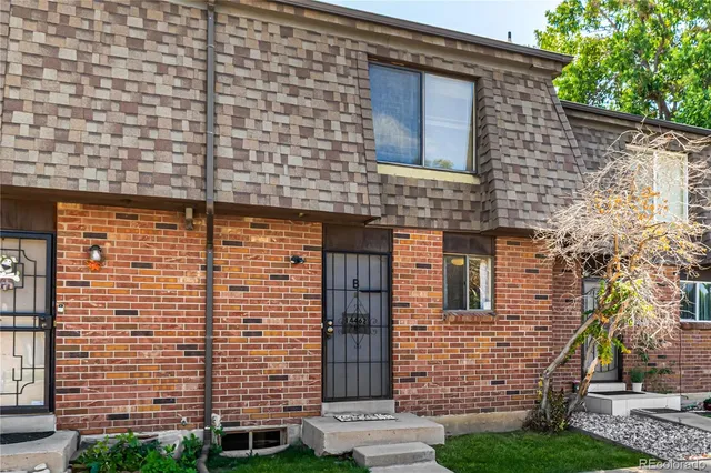 front view of a brick house with a yard