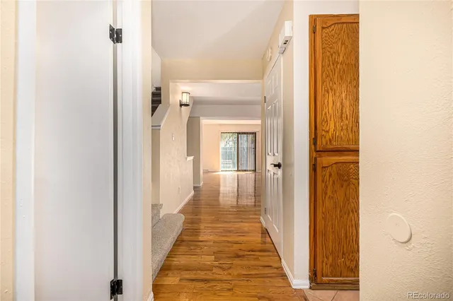 a view of a hallway with wooden floor and glass door