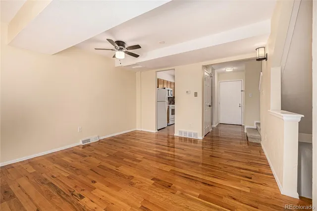 a view of empty room with wooden floor
