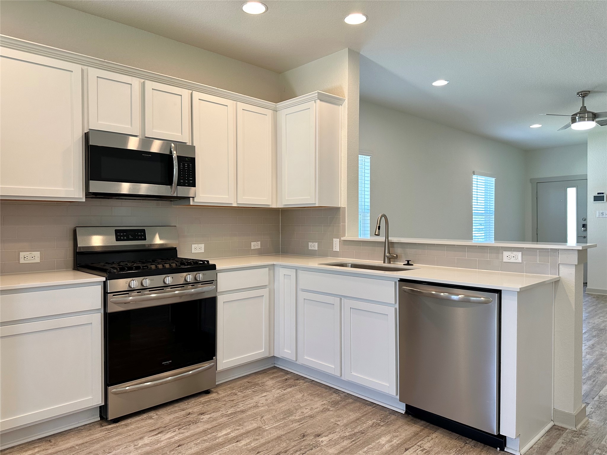 5132 Vanner Path Georgetown, TX 78626 - Photo 10 of 37 Kitchen featuring stainless steel appliances, white cabinetry, light wood-style floors, ceiling fan, and recessed lighting