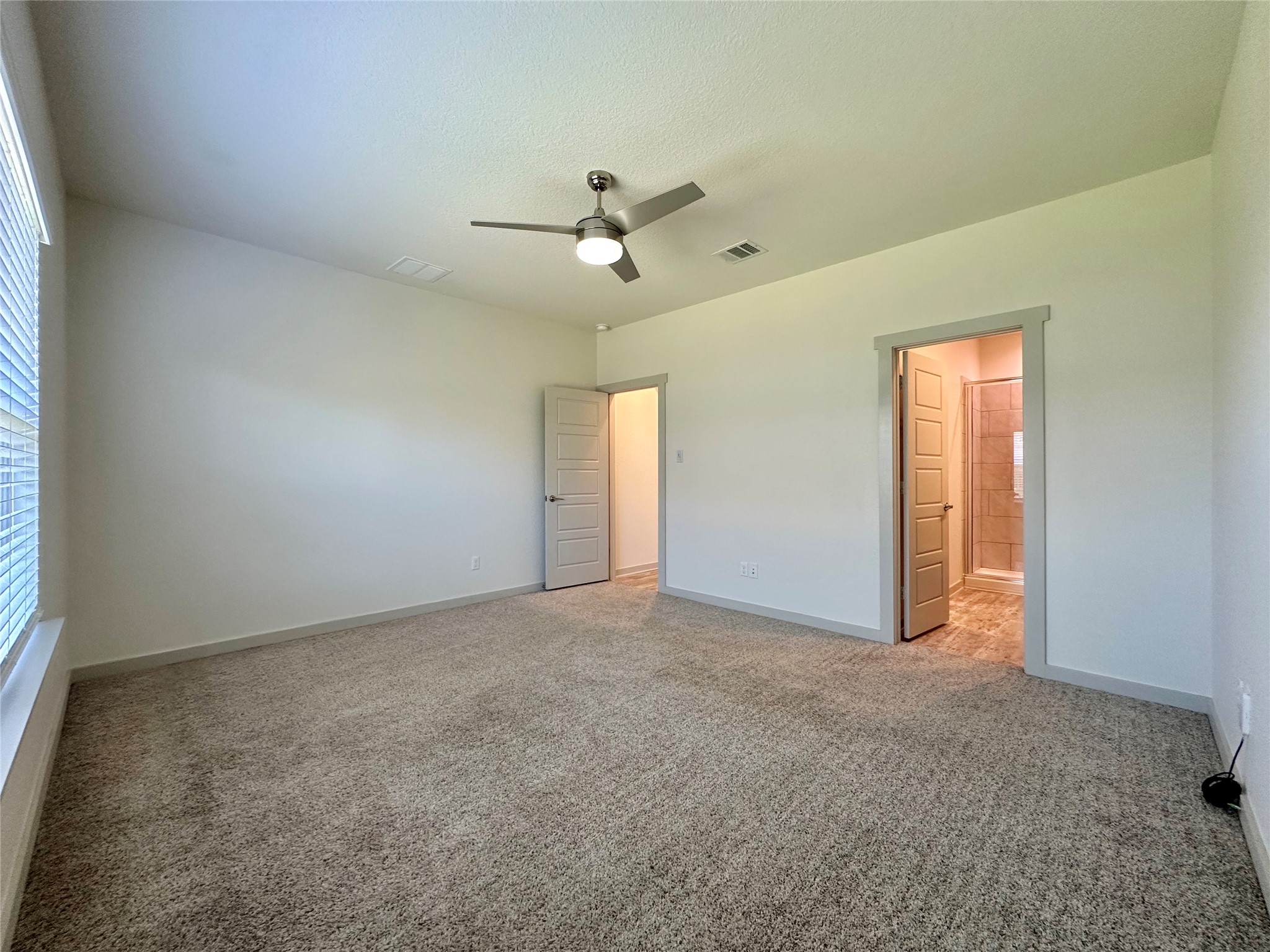 5132 Vanner Path Georgetown, TX 78626 - Photo 14 of 37 Unfurnished bedroom featuring light colored carpet, a ceiling fan, and ensuite bath