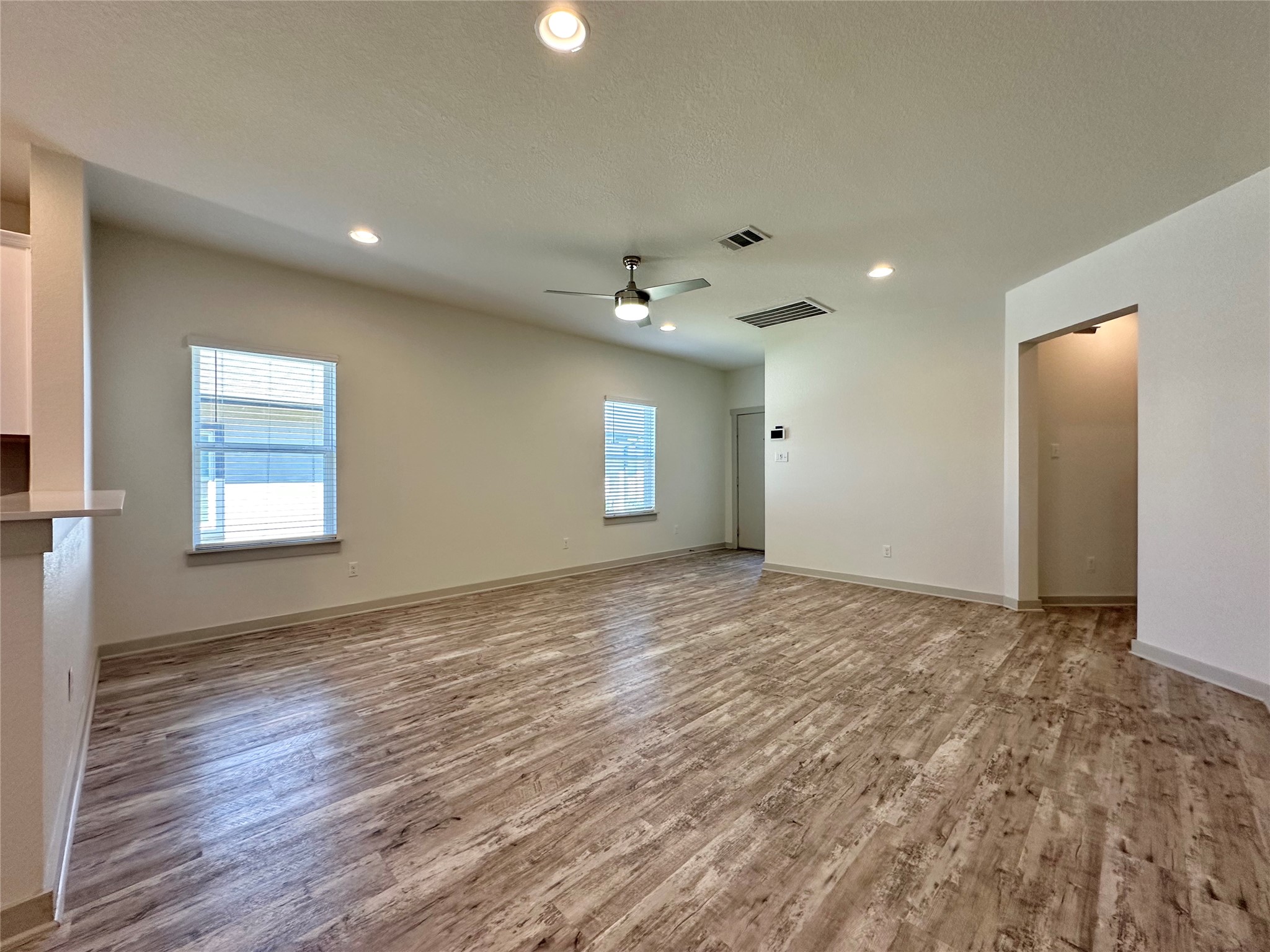 5132 Vanner Path Georgetown, TX 78626 - Photo 19 of 37 Unfurnished living room with a ceiling fan, wood finished floors, recessed lighting, and a textured ceiling