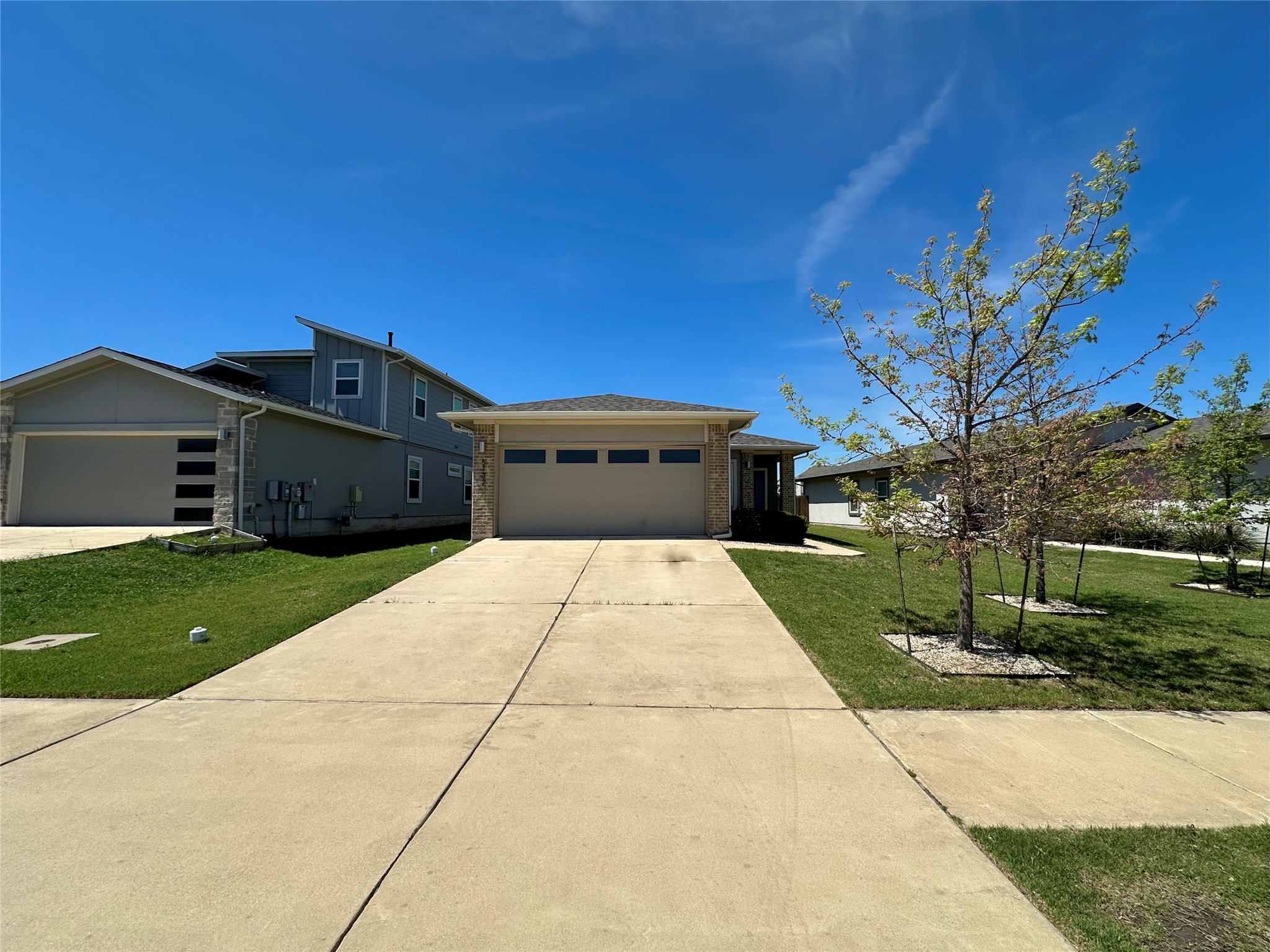 5132 Vanner Path Georgetown, TX 78626 - Photo 2 of 37 View of front facade featuring a garage, a front lawn, concrete driveway, and brick siding