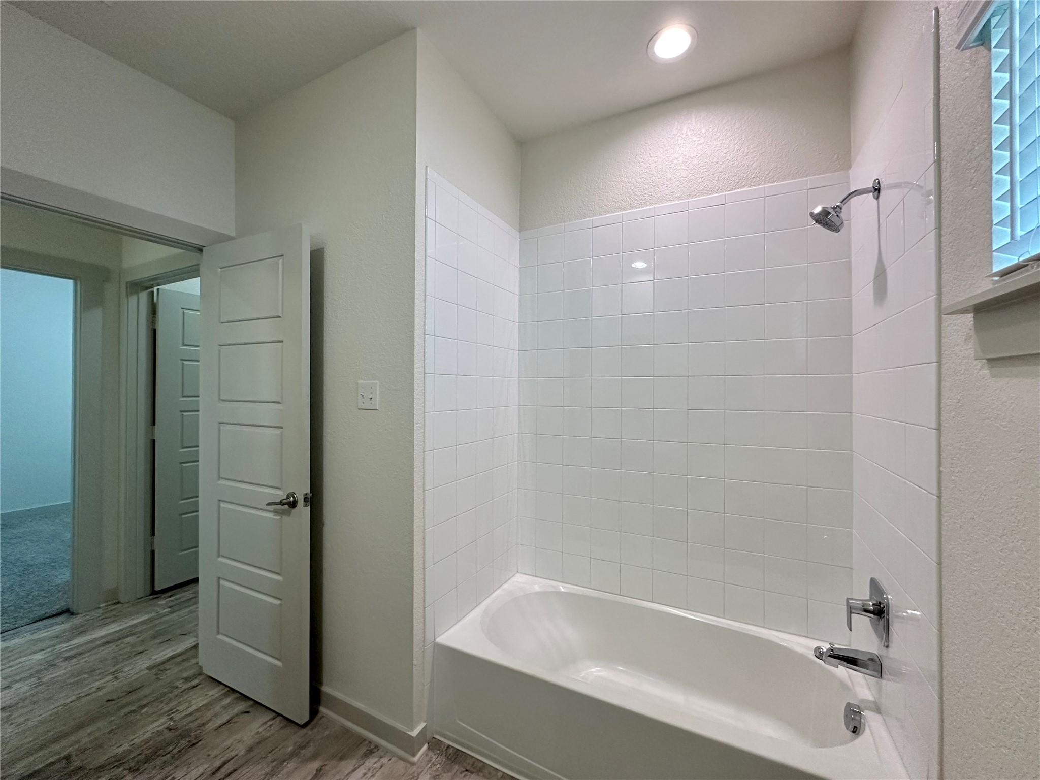 5132 Vanner Path Georgetown, TX 78626 - Photo 25 of 37 Bathroom featuring a textured wall, shower combination, and light wood-style flooring