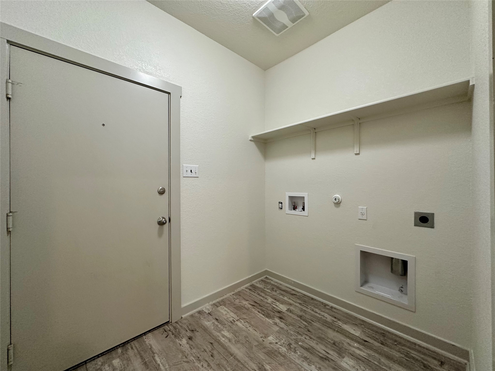 5132 Vanner Path Georgetown, TX 78626 - Photo 28 of 37 Laundry room featuring gas dryer hookup, light wood-type flooring, electric dryer hookup, washer hookup, and a textured ceiling