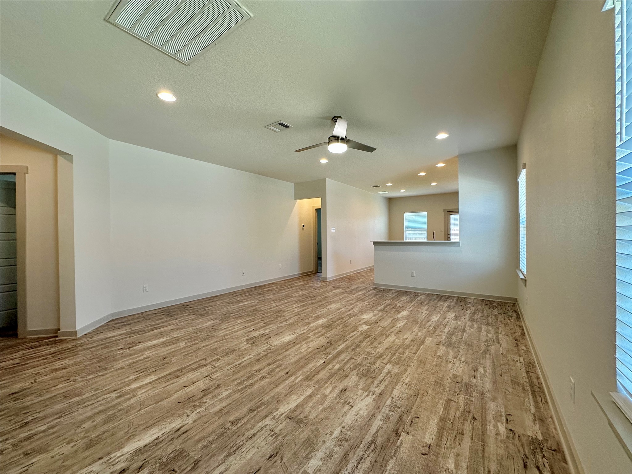 5132 Vanner Path Georgetown, TX 78626 - Photo 6 of 37 Unfurnished living room with light wood finished floors, ceiling fan, and recessed lighting