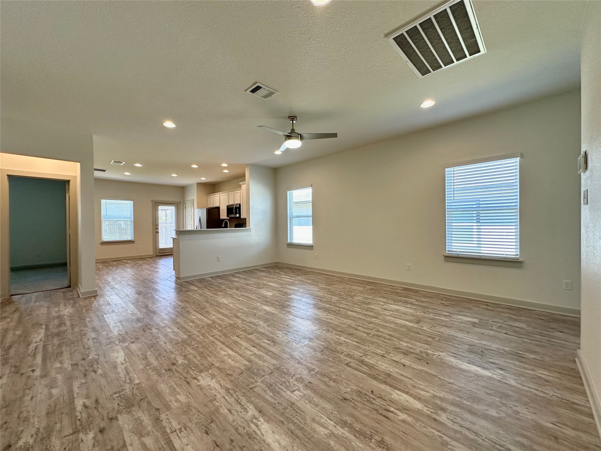 5132 Vanner Path Georgetown, TX 78626 - Photo 8 of 37 Unfurnished living room with light wood finished floors, ceiling fan, recessed lighting, and a textured ceiling
