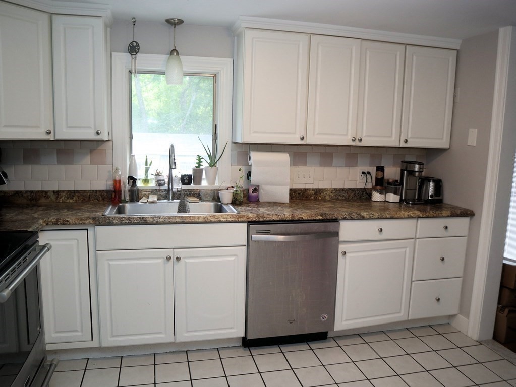 12 Tecumseh Road Bourne, MA 02562 - Photo 4 of 36 a kitchen with white cabinets appliances a sink and a window