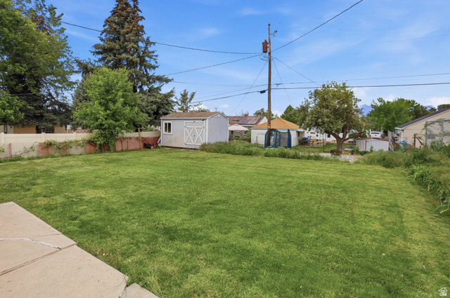 774 37th Street South Ogden, UT 84403 - Photo 32 of 47 Expansive green lawn area featuring a detached storage shed, mature perimeter trees, and a partial privacy fence