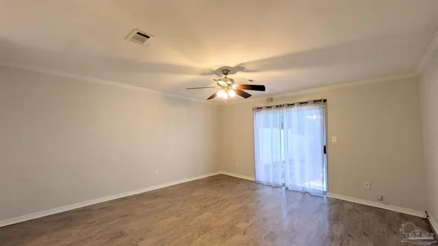 a view of an empty room with a chandelier fan