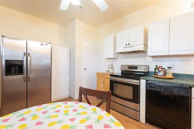 a kitchen with stainless steel appliances granite countertop a stove a refrigerator and a sink with cabinets