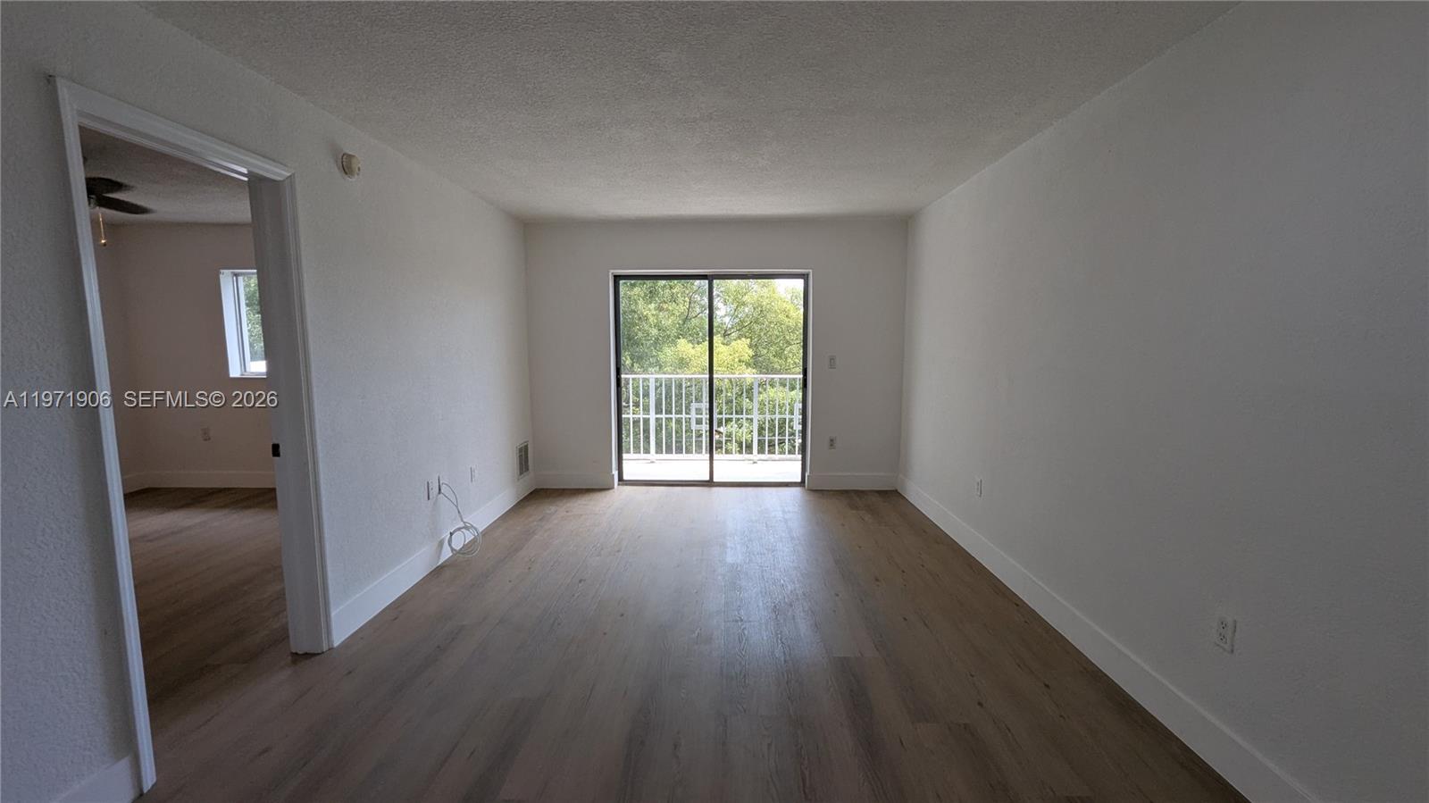 445 Southwest 11th Street, Unit 408 Miami, FL 33130 - Photo 11 of 29 wooden floor in an empty room with a window