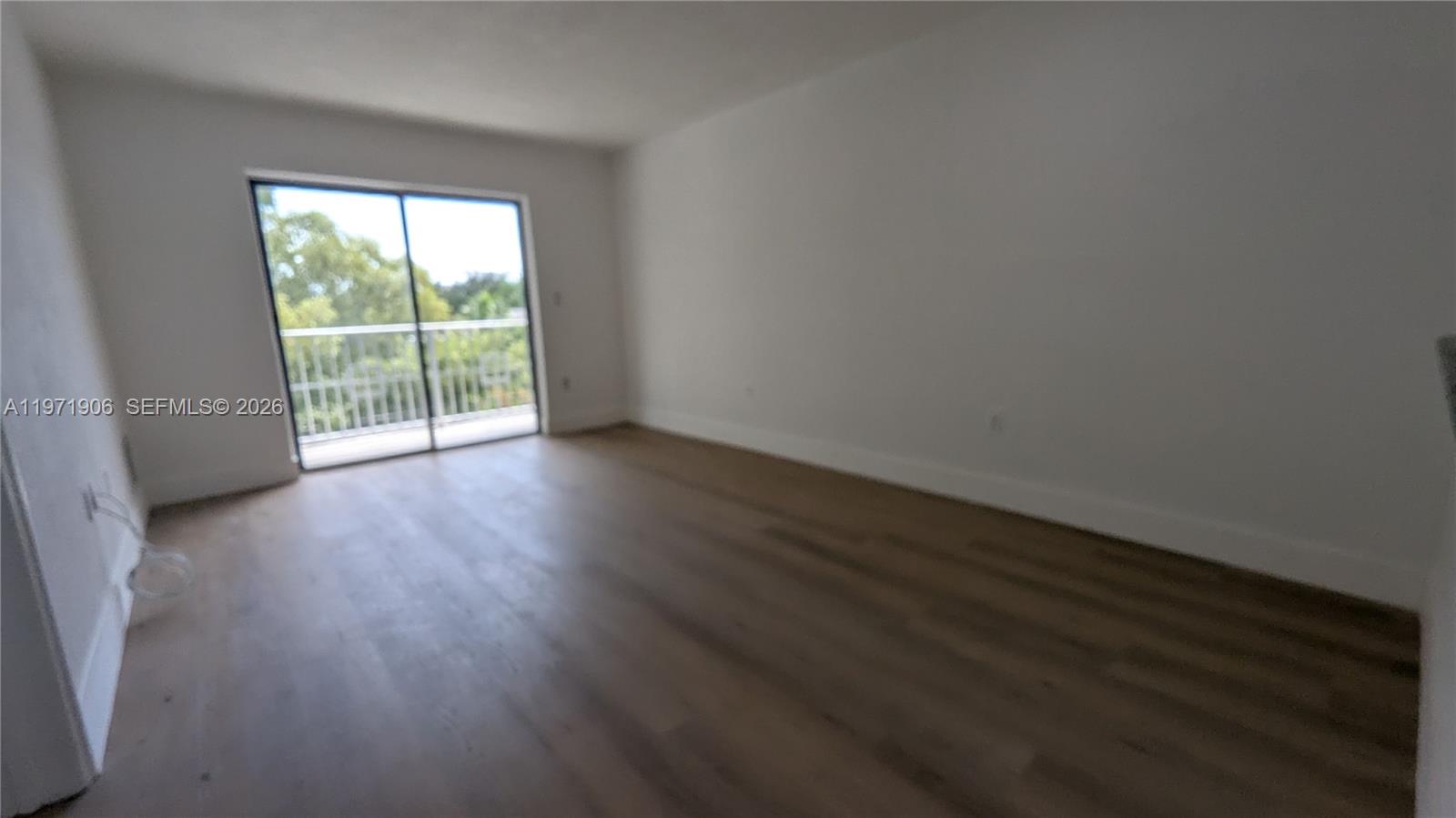 445 Southwest 11th Street, Unit 408 Miami, FL 33130 - Photo 13 of 29 a view of an empty room with wooden floor and a window