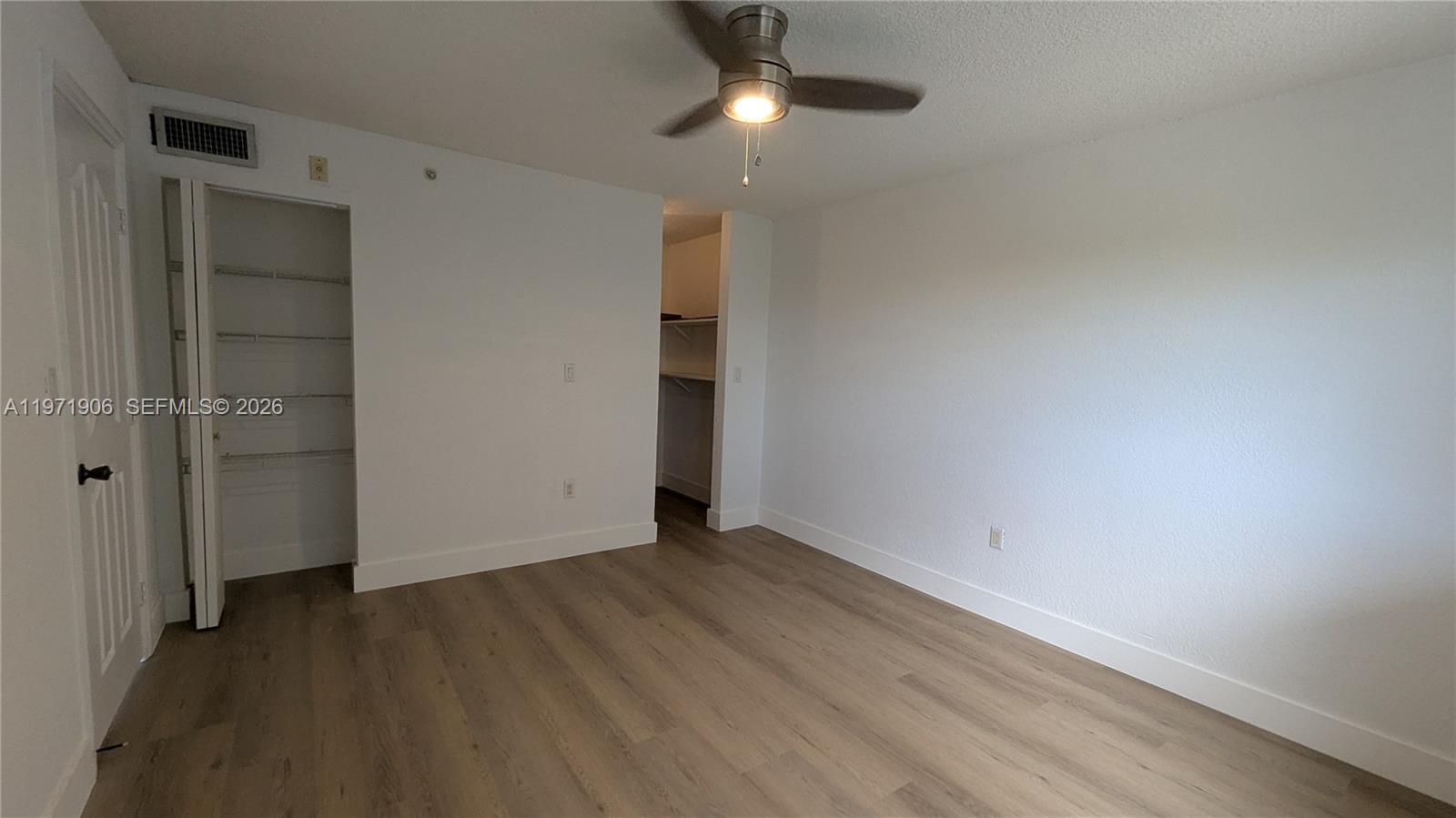 445 Southwest 11th Street, Unit 408 Miami, FL 33130 - Photo 28 of 29 an empty room with wooden floor closet and windows