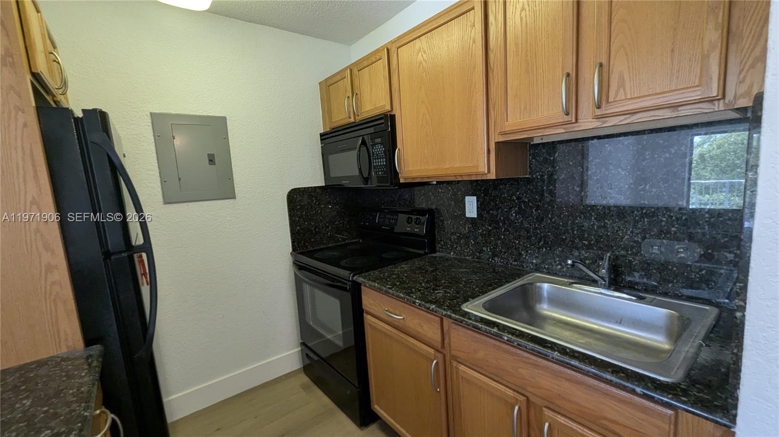 445 Southwest 11th Street, Unit 408 Miami, FL 33130 - Photo 7 of 29 a kitchen with granite countertop a sink stove and refrigerator