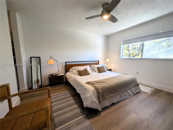 a bedroom with a bed lamp and a window