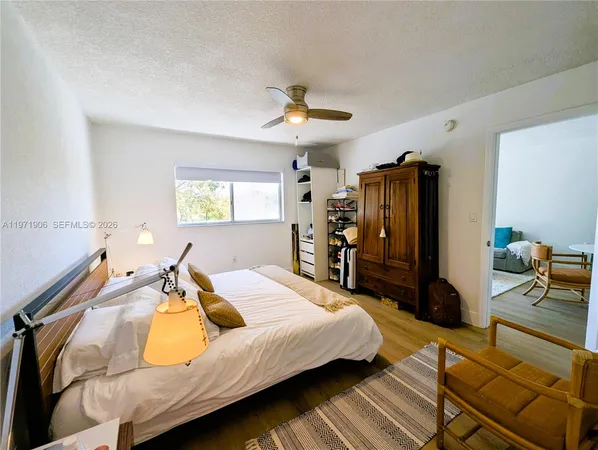 a bedroom with a bed flat screen tv and window