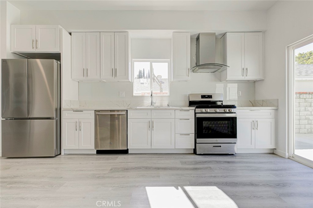 10499 Yolanda Avenue Porter Ranch, CA 91326 - Photo 11 of 37 a kitchen with stainless steel appliances a refrigerator stove and white cabinets